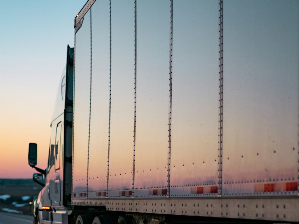 Transport truck hauling freight on the highway at sunset