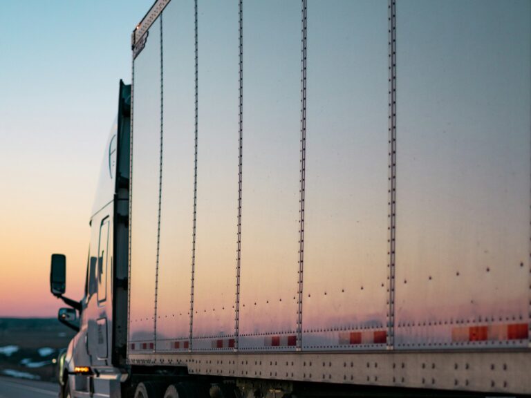 Transport truck hauling freight on the highway at sunset