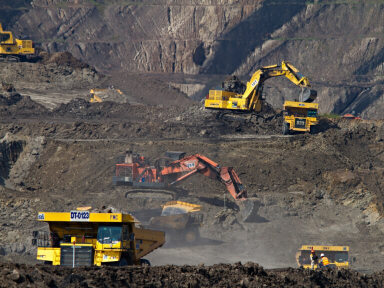 Excavators and haul trucks working in an open-pit mine